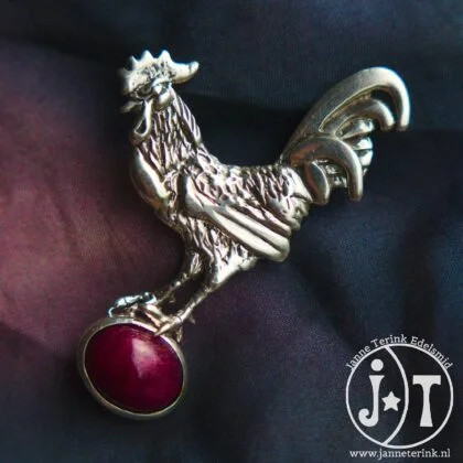 Haan broche met robijn