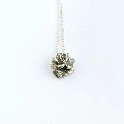 Een handgemaakte zilveren gedetailleerde roosvormige hanger.