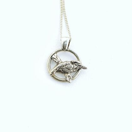 Handgemaakte zilveren IJsvogel hanger aan een ketting op een witte achtergrond.