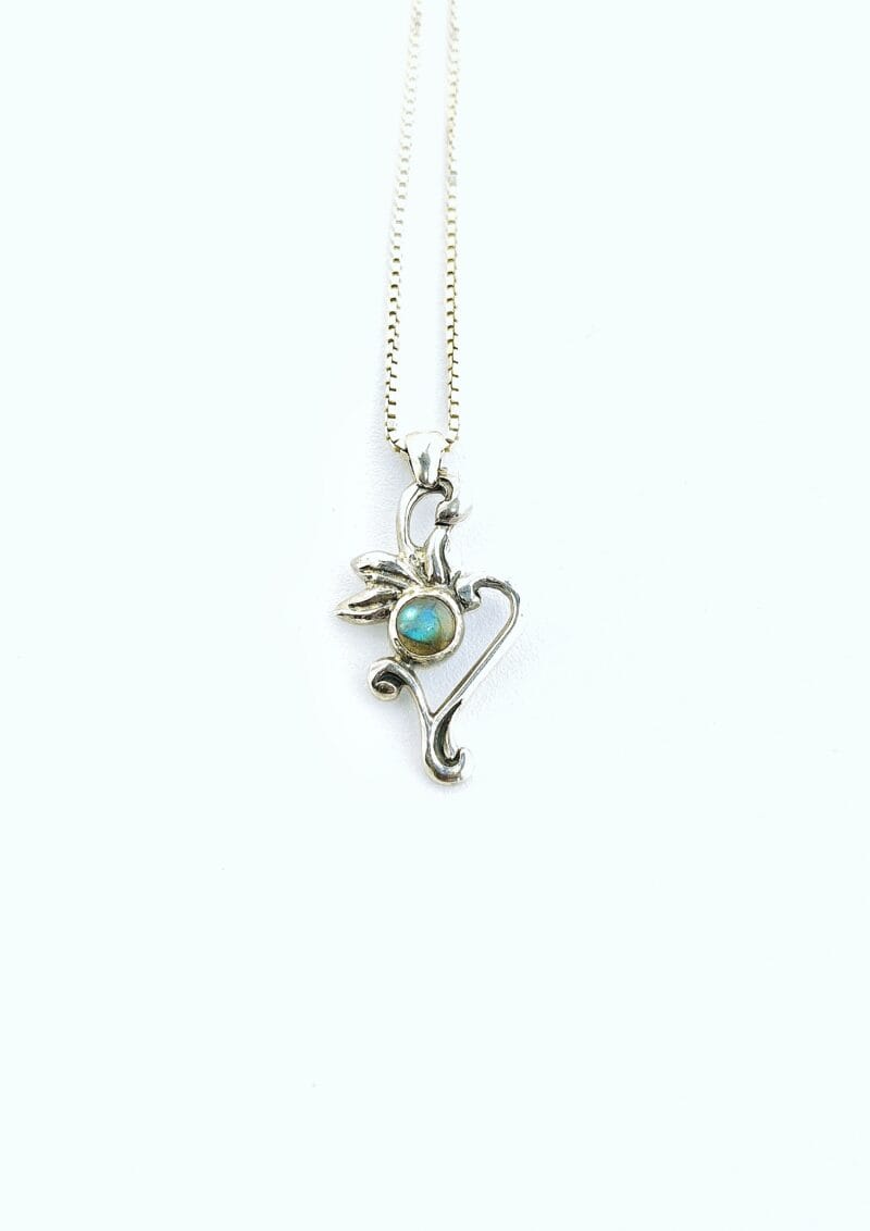 Een zilveren hanger met een bloem en plantvormig hangertje en een ronde, blauw iriserende labradoriet cabochon in het midden.